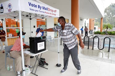 A poll worker casts a mail-in ballot for a disabled driver on the last day of early voting for the US presidential election, Florida, Aug. 16, 2020. (Reuters)