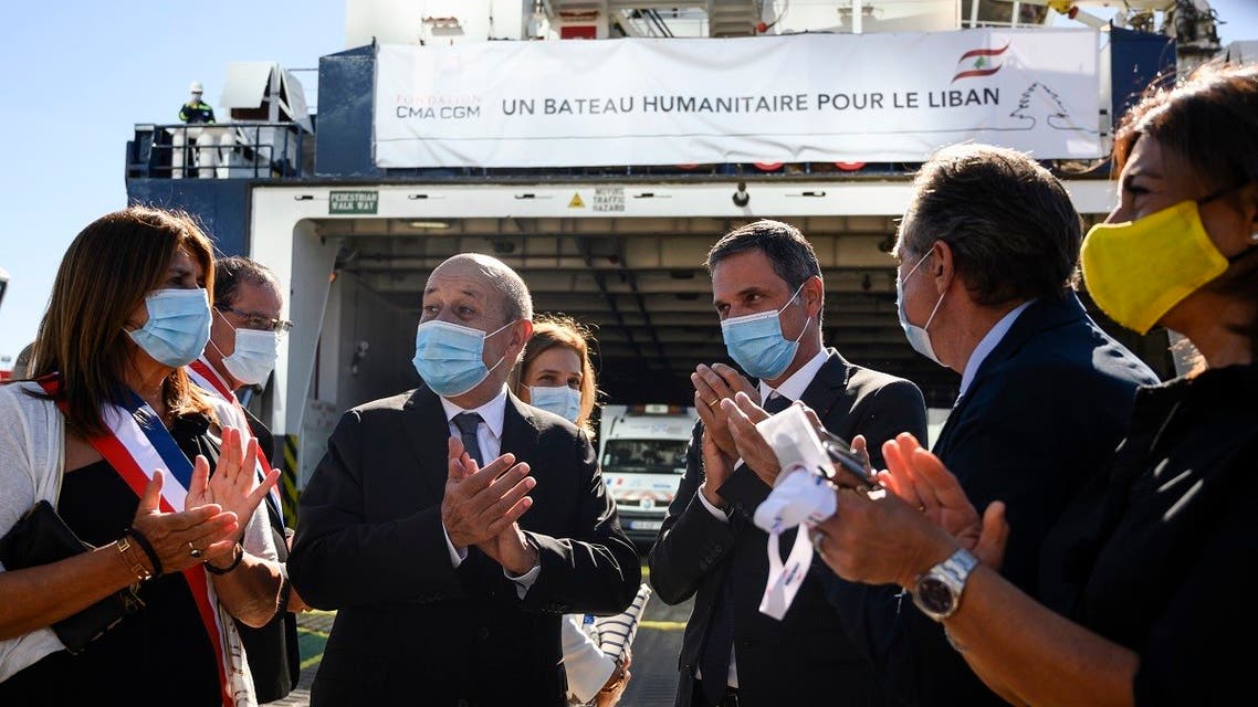French European and Foreign Affairs Minister Jean-Yves Le Drian (2nd L) in front of a container ship loaded with humanitarian aid bound for Lebanon . (AFP)