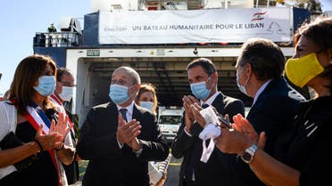 French Foreign Affairs Minister Jean-Yves Le Drian (2nd L) in front of a ship with humanitarian aid bound for Lebanon. (AFP)
