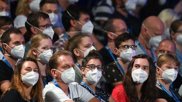 People wear face masks as German pop singer Tim Bendzko performs on stage at the Arena in Leipzig, eastern Germany. (AFP)