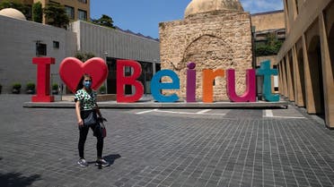 2020-08-A woman wearing a face mask walks past an I love Beirut sign, near a shopping district, as Lebanon imposed a partial lockdown for two weeks starting on Friday in an effort to counter the spread of the coronavirus disease (COVID-19), which have spiralled since the catastrophic explosion at Beirut port, Lebanon August 21, 2020. REUTERS-CORONAVIRUS-LEBANON-LOCKDOWN