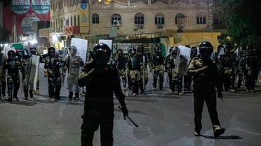 Riot police try to prevent protesters from storming the Iraqi Parliament Building during protests in Basra, Iraq, Friday, Aug. 21, 2020. Demonstrators burned the outer gate of the entrance to the parliament building in Basra province, the area that produces the lion's share of the crude exporting country's oil. The country's main parliament building is in the capital Baghdad. (AP Photo/Nabil al-Jurani)