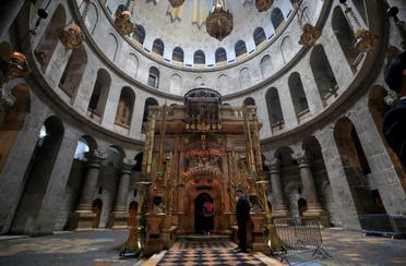 Visitors walk past the Edicule in the Church of the Holy Sepulchre in the Old City of Jerusalem on March 15, 2020. (AFP)