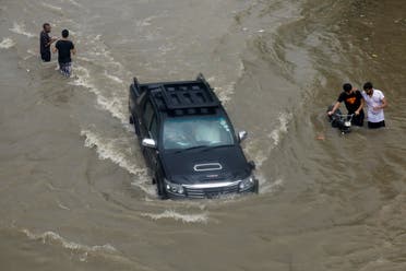 A vehicle passes through the flooded street during monsoon rain, as the outbreak of the coronavirus disease (COVID-19) continues, in Karachi. (Reuters)