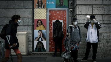 People wearing face masks stand by a cash machine on May 11, 2020 in Lyon, France. (File photo: AFP)