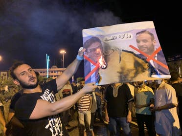 A Libyan protester burns an image of Libyan officials as he protests over announcement of suspension of the Interior Minister Fathi Bashagha during an anti-government protest in Misrata, Libya August 29, 2020. (Reuters)