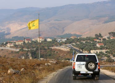 A UN peacekeepers (UNIFIL) vehicle drives past a Hezbollah flag in the southern Lebanese village of Khiam, near the border with Israel, Lebanon. (File photo: Reuters)