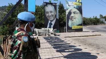 UNIFIL soldiers stand near a poster of Hezbollah leader Hassan Nasrallah and Speaker Nabih Berri, near the Lebanese-Israeli border, Aug. 7, 2020. (Reuters)
