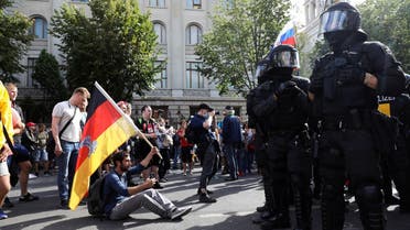 A demonstrator sits in front of police officers as he attends a rally against the government's restrictions following the coronavirus in Berlin, Germany, August 29, 2020. (Reuters)
