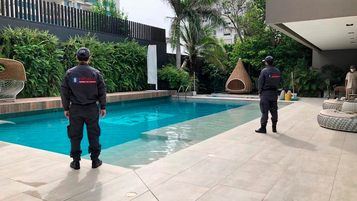 officials pose with their backs to the camera by a pool on a property allegedly belonging to Alex Saab in Barranquilla, Colombia. (AP)