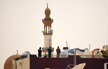 Workers pray on the roof of a residential building near a mosque during a curfew imposed to prevent the spread of coronavirus disease (COVID-19) in the Gulf Emirate of Dubai, on April 21, 2020. (AFP)