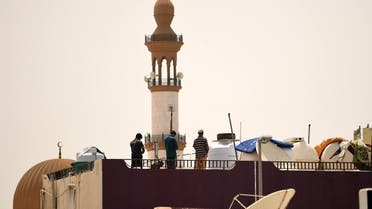 Workers pray on the roof of a residential building near a mosque during a curfew imposed to prevent the spread of coronavirus disease (COVID-19) in the Gulf Emirate of Dubai, on April 21, 2020. (AFP)