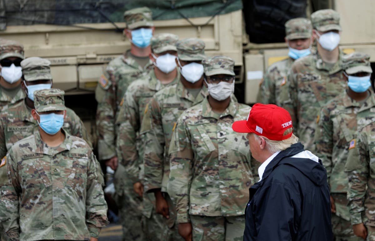 U.S. President Donald Trump looks at members of National Guard wearing masks in formation at Cougar Stadium as he visits nearby areas damaged by Hurricane Laura in Lake Charles, Louisiana, U.S. (Reuters)