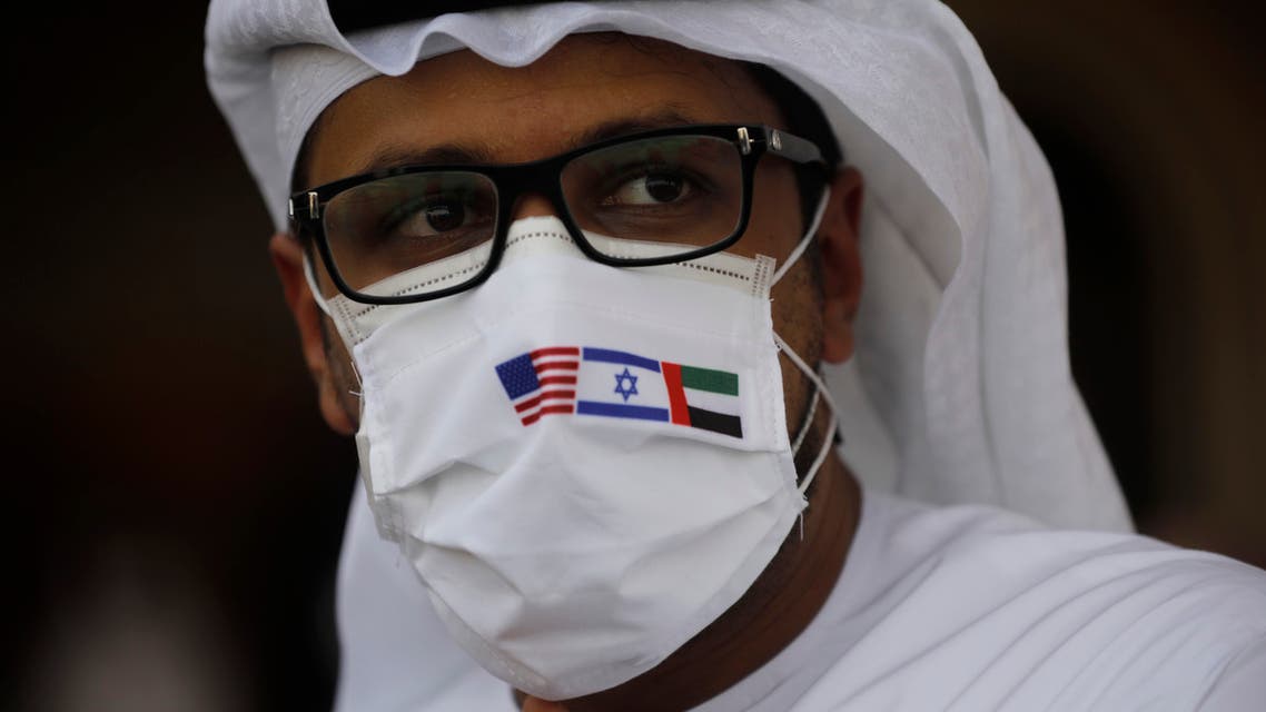 A man wearing a mask bearing the national flags of America, Israel and United Arab Emirates in Abu Dhabi on Aug. 31, 2020. (AP)
