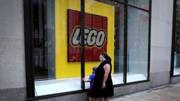 A woman and a child look through the windows of the closed Lego store at Rockefeller Center on 5th Avenue, during the outbreak of the coronavirus, in Manhattan, New York city, New York, US, May 11, 2020. (Reuters)