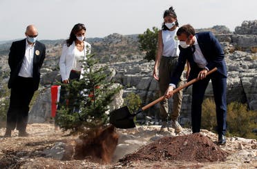 French President Emmanuel Macron plants a cedar with members of the NGO Jouzour Loubnan in Jaj, near Beirut, Tuesday Sept. 1, 2020. (AP)