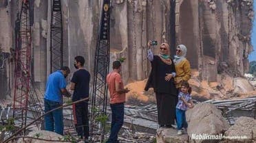 A photograph showing two people taking a selfie in front of the Beirut blast. (Rami Chakroun, Twitter)