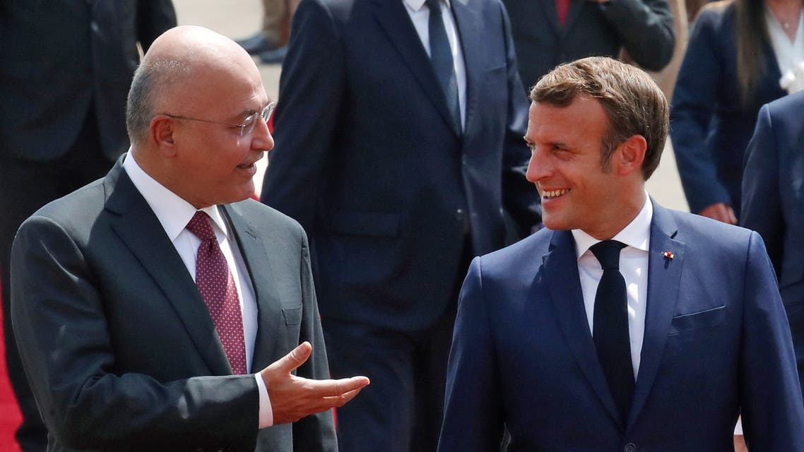 Iraqi President Barham Saleh (L) welcomes his French counterpart Emmanuel Macron as he arrives at the Salam Palace in Baghdad. (AFP)