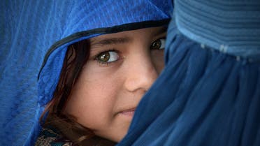 An Afghan woman carries her girl during the visit of the United Nations High Commissioner for Refugees, Filippo Grandi (unseen) at the Azakhel Voluntary Repatriation Centre in Nowshera on September 8, 2018. (File photo: AFP)