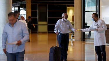 Passengers receive brochures that contain medical tips to prevent coronavirus at Queen Alia International Airport in Amman, Jordan March 4, 2020. (Reuters)