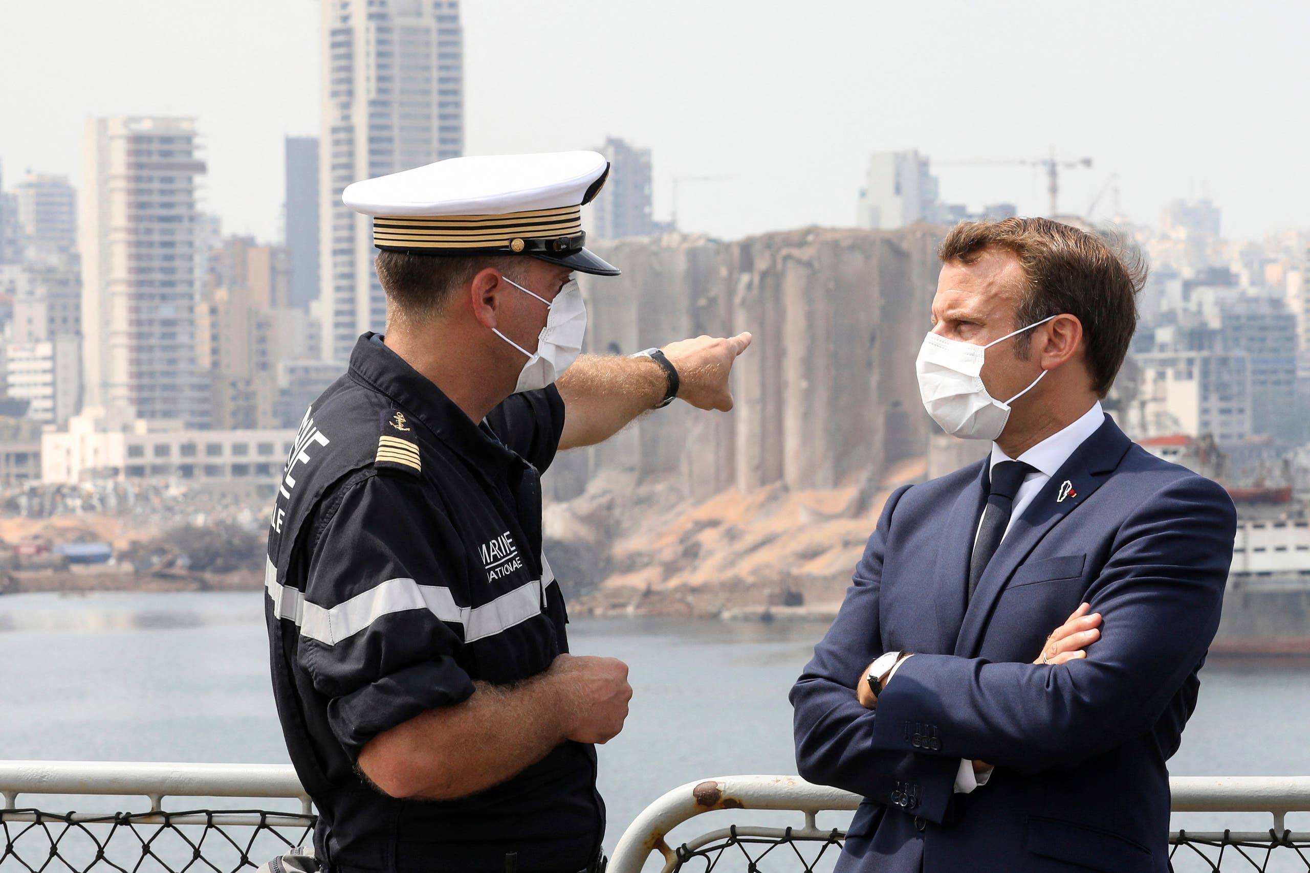 Arnaud Tranchant, left, chief Navy officer for the French helicopter carrier Tonnerre, talks to French President Emmanuel Macron off the port of Beirut on Sept.1, 2020. (AP)