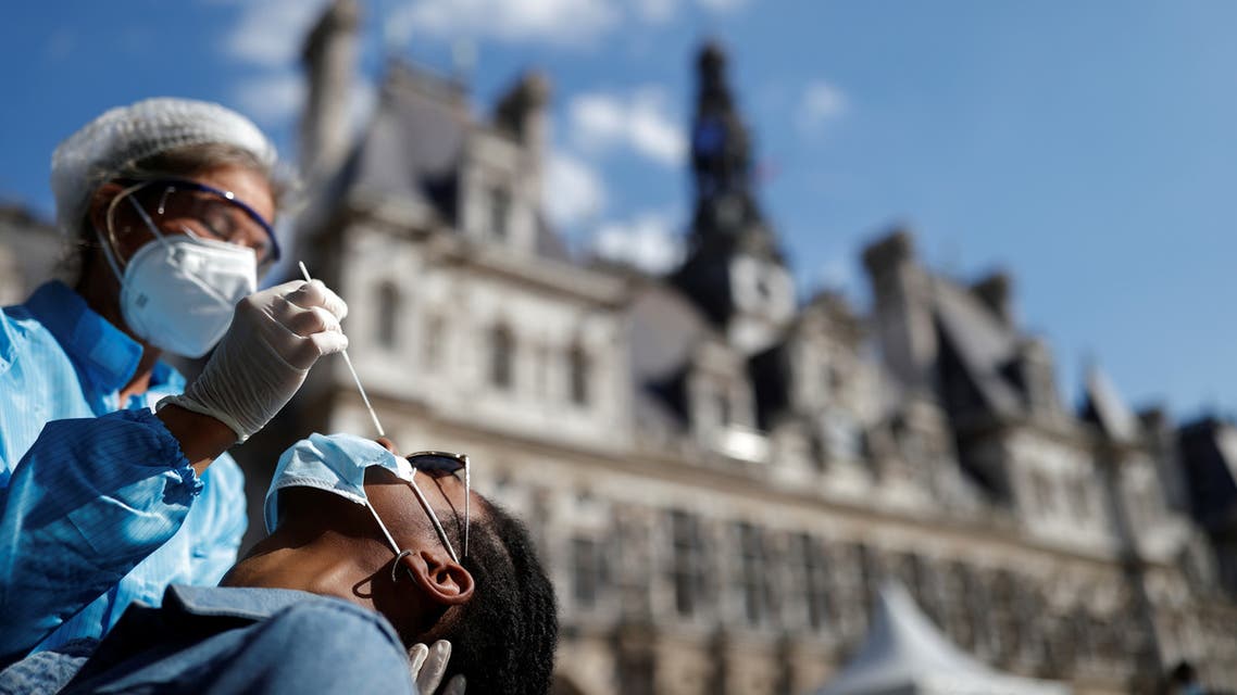 A health worker, wearing a protective suit and a face mask, prepares to administer a nasal swab to a patient at a testing site for the coronavirus disease installed in front of the city-hall in Paris, France, September 2, 2020. (Reuters)