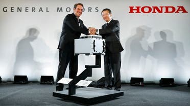 Mark Reuss, General Motors executive vice president of Global Product Development, left, and Toshiaki Mikoshiba, chief operating officer of the North American Region for Honda Motor Co., Ltd., shake hands at a news conference announcing the GM-Honda Next Generation Fuel Cell in Detroit. (AP)