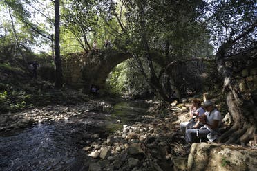 Lebanese protesters take a break by the 'Roman Bridge' during a 20km (12 miles) march in the Bisri Valley, southwest of the capital Beirut on November 22, 2019. (AFP)