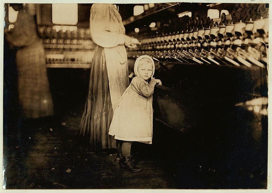 صورة لطفلة اثناء عملها بمصنع النسيج