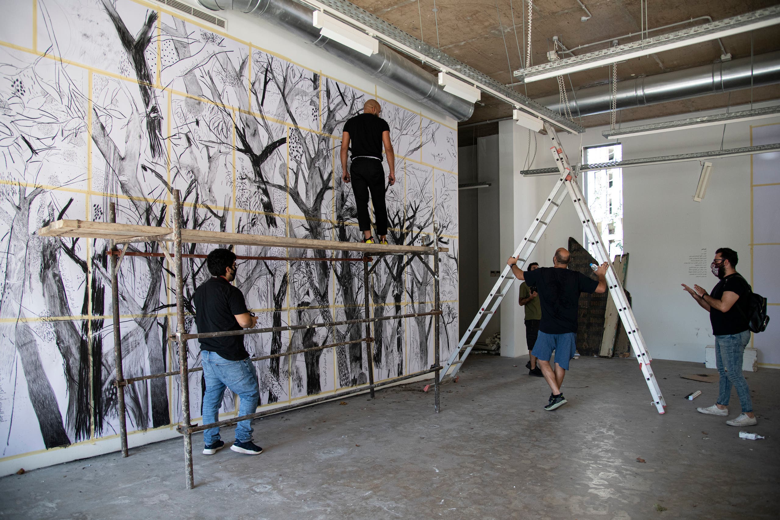 Abed Al Kadiri is shown during the process of creating the first mural, which took about two weeks to complete. (Photo courtesy of Laetita Hakim.)