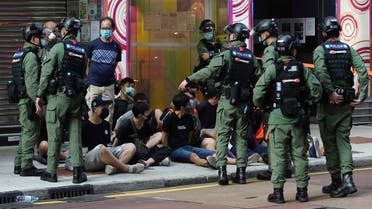 People, sitting on the ground, are arrested by police officers at a downtown street in Hong Kong on Sept. 6, 2020. (AP)