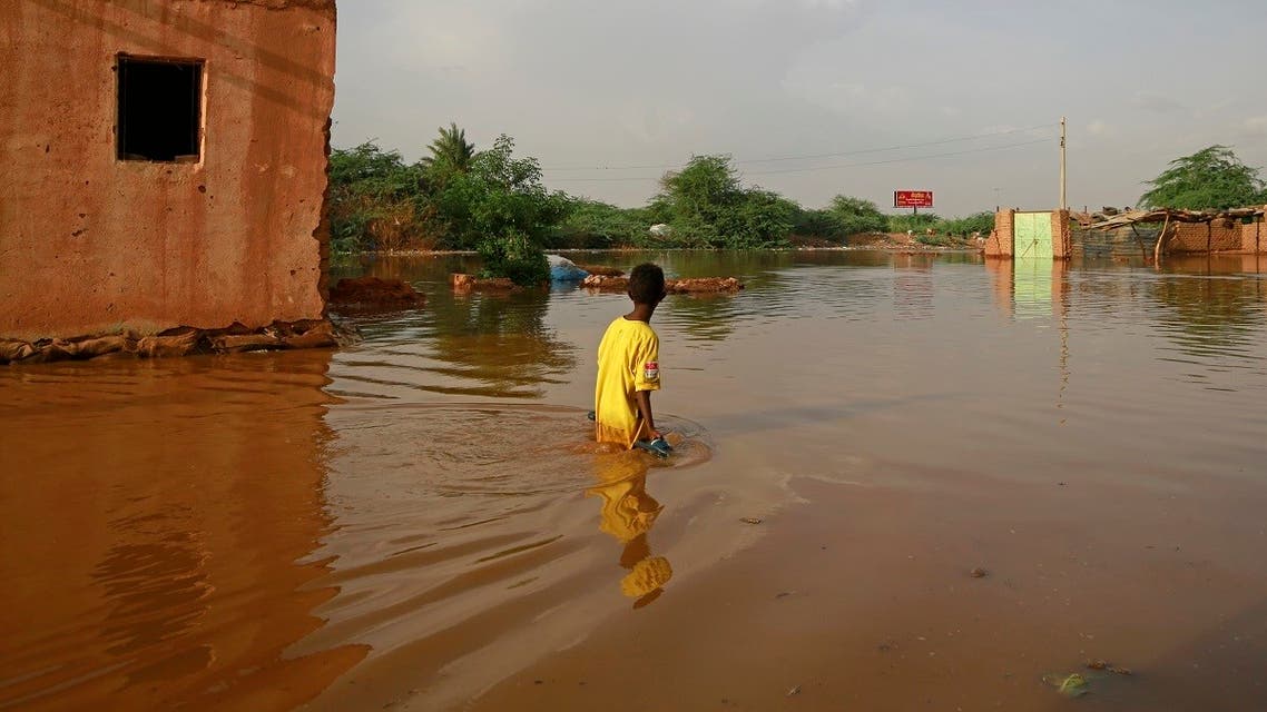 A Sudanese boy wades through a flooded street at the area of al-Qamayir in the capital's twin city of Omdurman. (AFP)