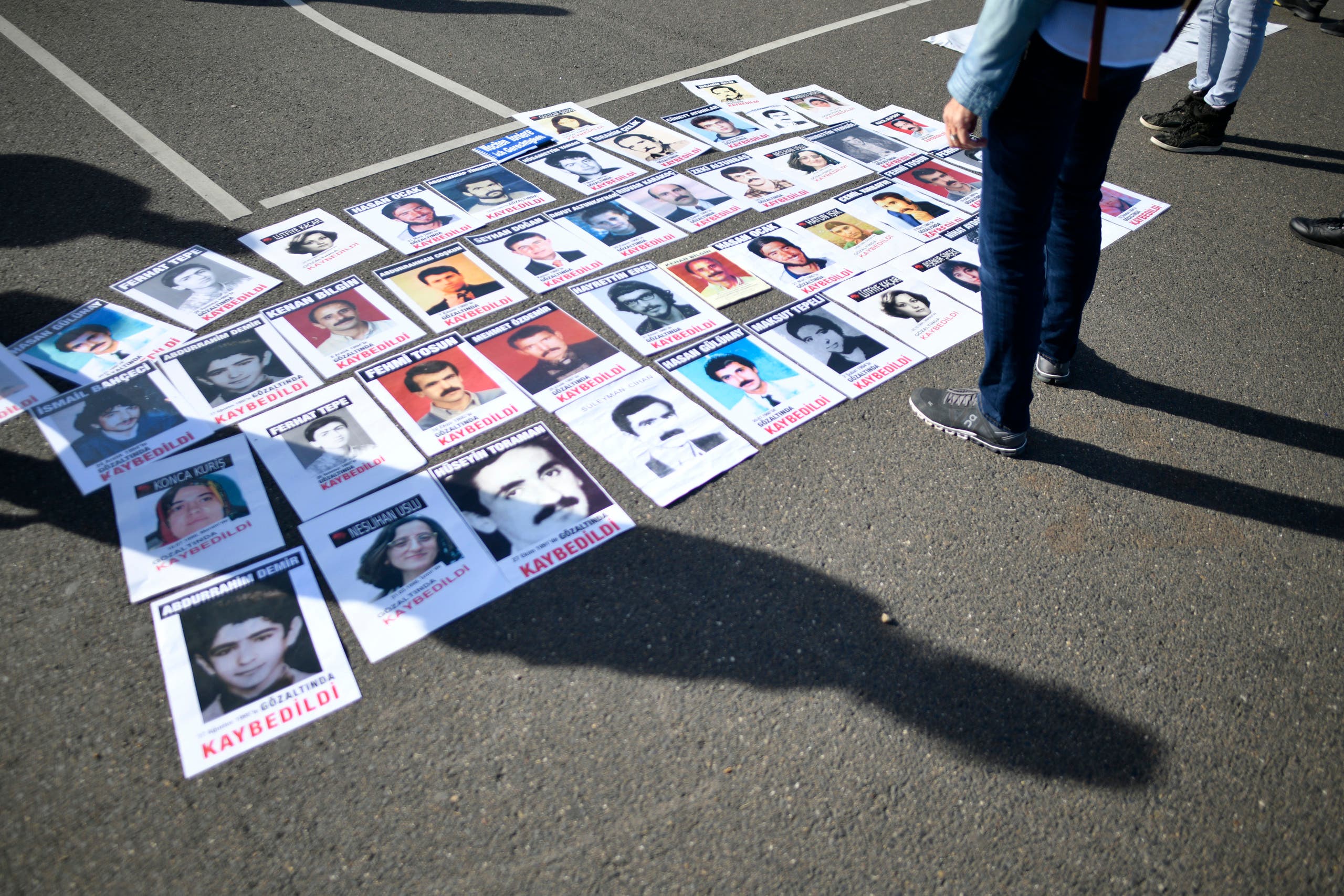 Photos of Turkish people who died in jail in Turkey lay on the ground during a demonstration in Cologne prior to the visit of the Turkish President to Cologne, on September 29, 2018. (AFP)