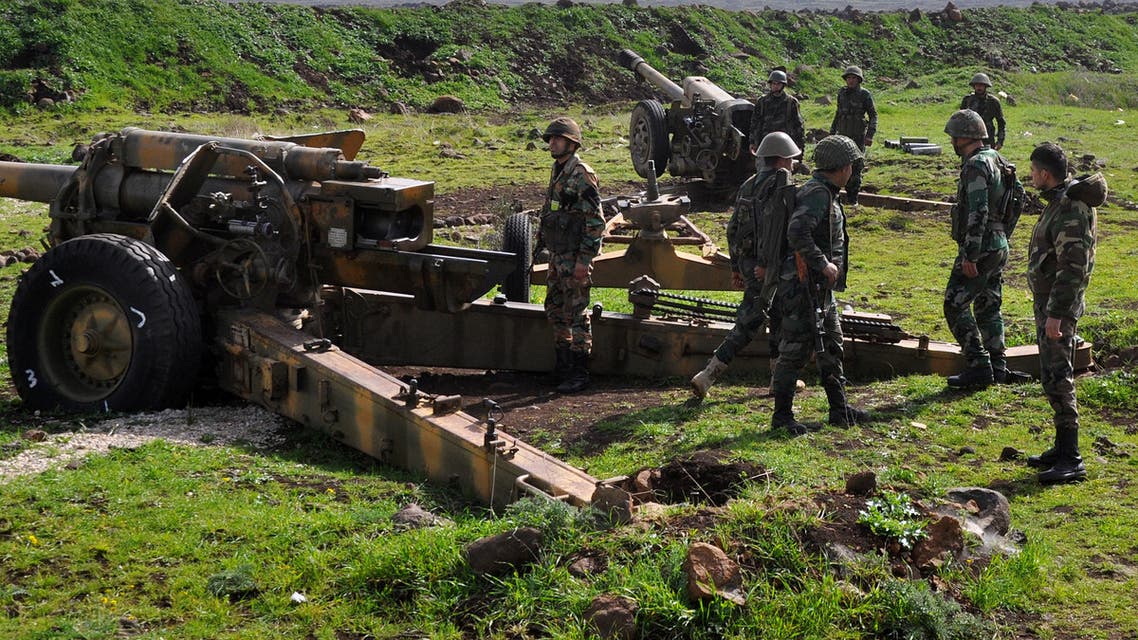 Syrian government forces stand near an artillery gun as they take position in the area between Talbiseh and Rastan in the northern countryside of Homs on March 1, 2018.
