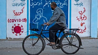 A Syrian man rides a bicycle past a mural painted as part of an awareness campaign by the United Nations International Children's Emergency Fund (UNICEF) and World Health Organization (WHO) initiative on coronavirus in Qamishli, Syria, August 16, 2020. (AFP)