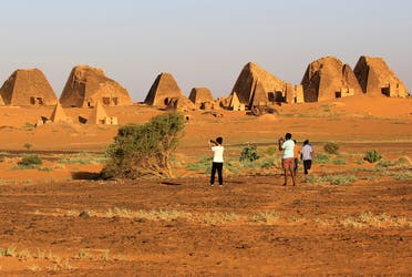 Tourists take pictures of the Royal Cemeteries of Meroe Pyramids in Begrawiya at River Nile State. (Reuters)