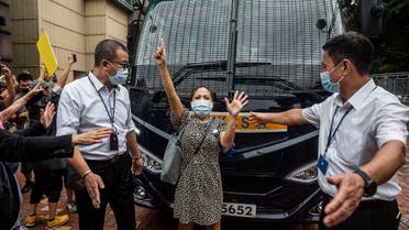A pro-democracy supporter (C) gestures “five demands, not one less” as she blocks a prison van transporting democracy activist Tam Tak-chi after he was denied bail and charged with sedition at the Fanling magistrates court in Hong Kong on September 8, 2020. (AFP)