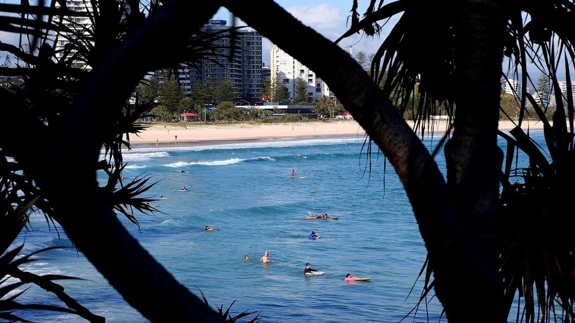 Surfers wade in the water waiting for waves off the Southern Gold Coast area of Greenmount Beach, Gold Coast. (AP)
