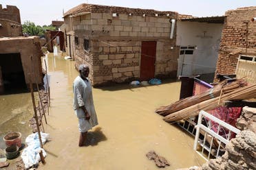 A man passes on the side of a flooded road in the town of Alkadro, about (20 km) north of the capital Khartoum, Sudan. (AP)
