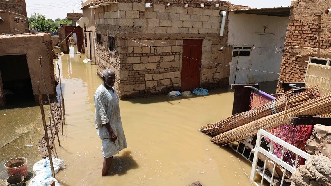 A man passes on the side of a flooded road in the town of Alkadro, about (20 km) north of the capital Khartoum, Sudan. (AP)