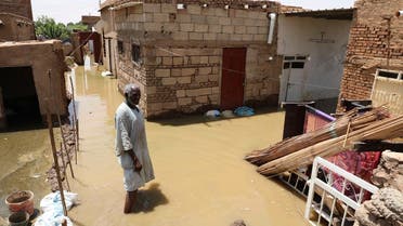 A man passes on the side of a flooded road in the town of Alkadro, about (20 km) north of the capital Khartoum, Sudan. (AP)