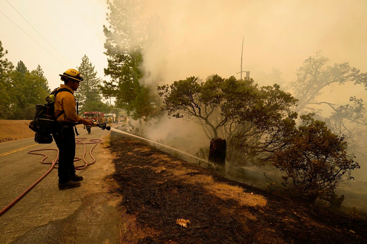 Rick Archuleta of the Clovis Fire Department hoses down hotspots left behind by the Creek Fire, Sept. 8, 2020, in Tollhouse, Calif. (AP)