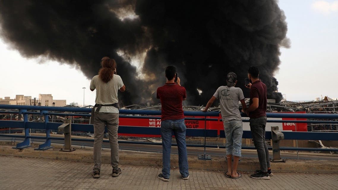 People take pictures as smoke rises after a fire broke out at Beirut's port area, Lebanon. (Reuters)