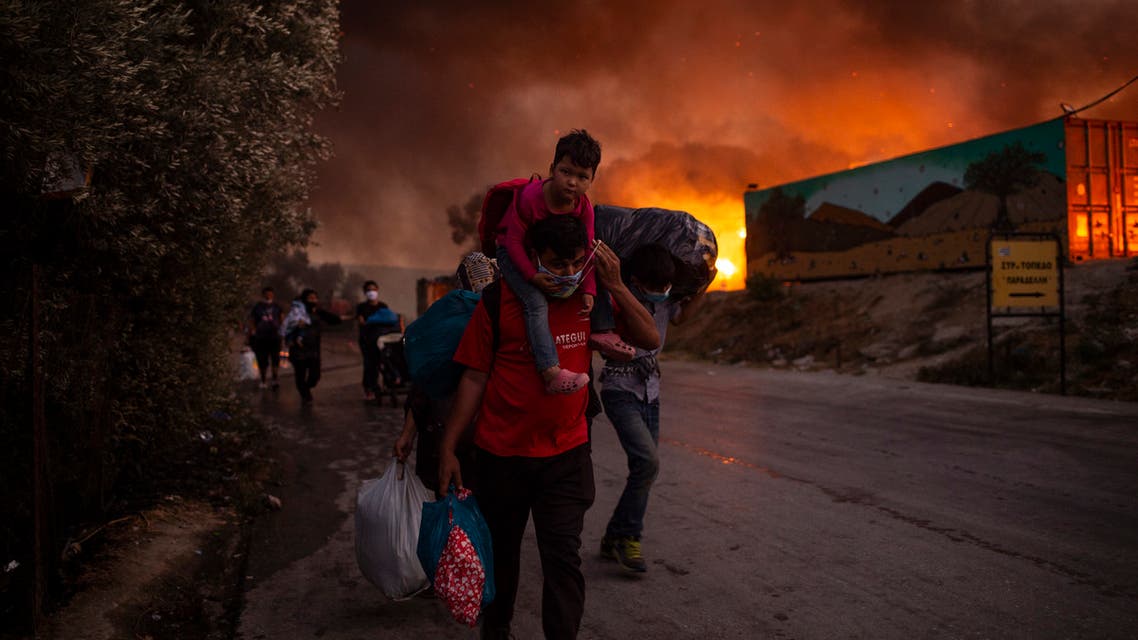 People with children flee flames after a major fire broke out in the Moria migrants camp on the Greek Aegean island of Lesbos. (AFP)