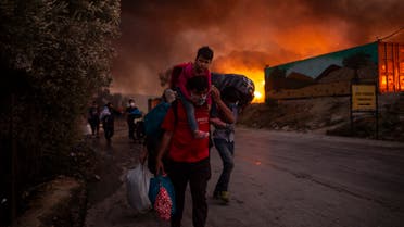 People with children flee flames after a major fire broke out in the Moria migrants camp on the Greek Aegean island of Lesbos. (AFP)