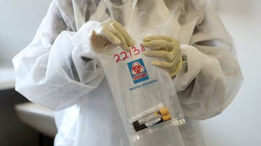 A health worker holds a COVID-19 sample collection kit of a vaccine trials' volunteer at the Wits RHI Shandukani Research Centre in Johannesburg. (Reuters)