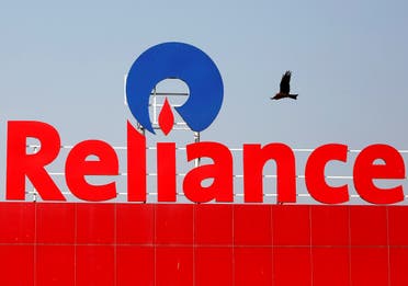 A bird flies past a Reliance Industries sign in Ahmedabad, India. (Reuters)