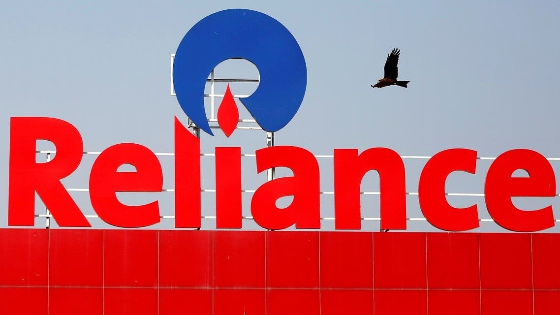 A bird flies past a Reliance Industries sign in Ahmedabad, India. (Reuters)