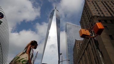 A woman wearing a protective face mask walks by One World Trade Center two days before the 19th anniversary of the 9/11 attacks, amid the coronavirus disease, in the lower section Manhattan, New York City, US, September 9, 2020. (Reuters)