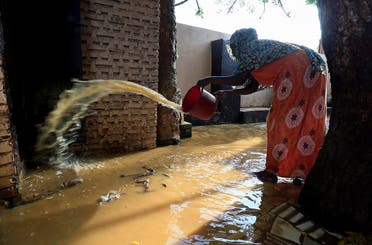 A resident pours out the waters of the Blue Nile floods from her backyard within the Al-Ikmayr area of Omdurman in Khartoum, Sudan. (Reuters)